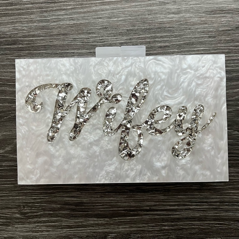 White and silver/glitter “wifey” clutch bag